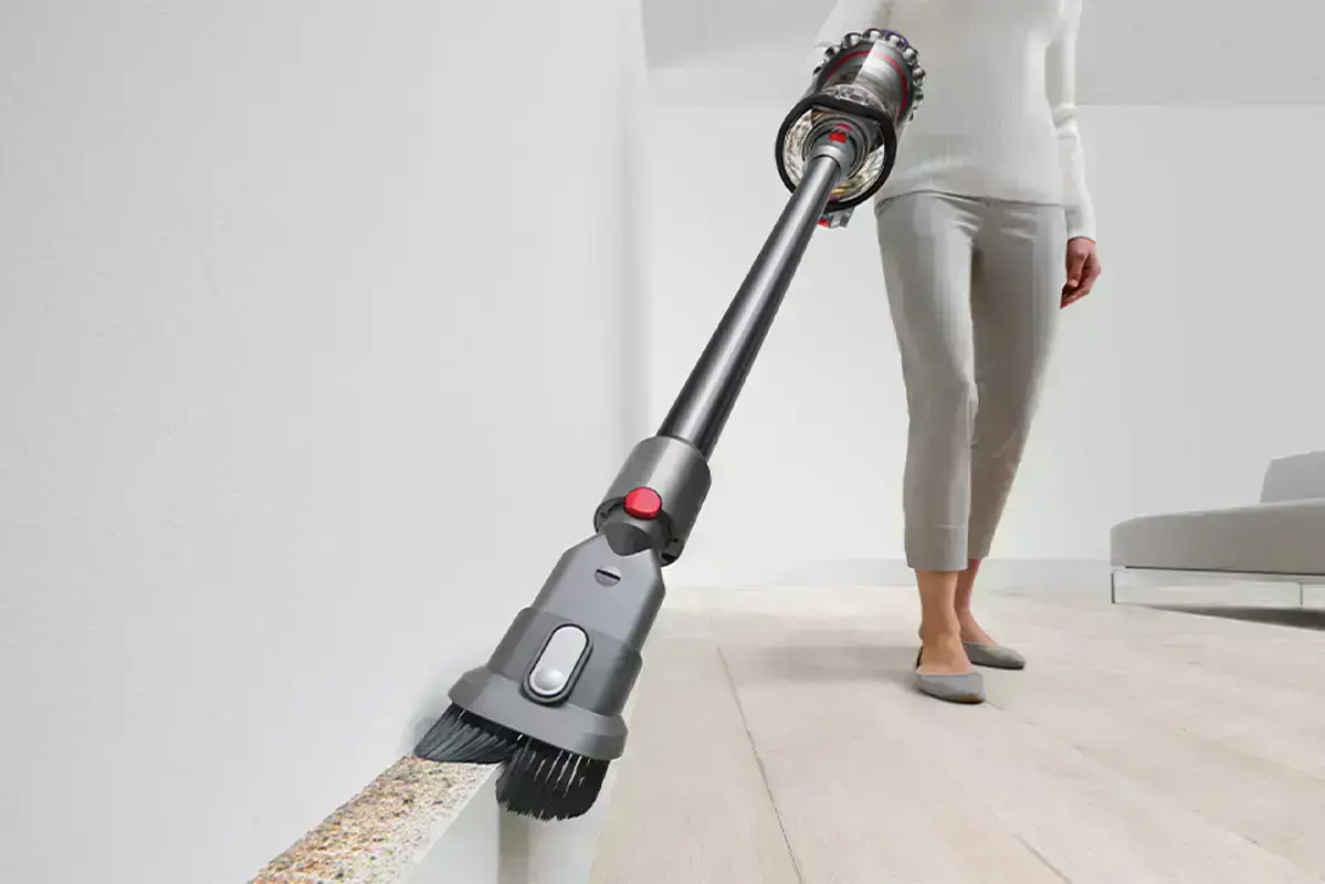 жінка збирає пил комбінованою насадкою в пилососі dyson outsize plus