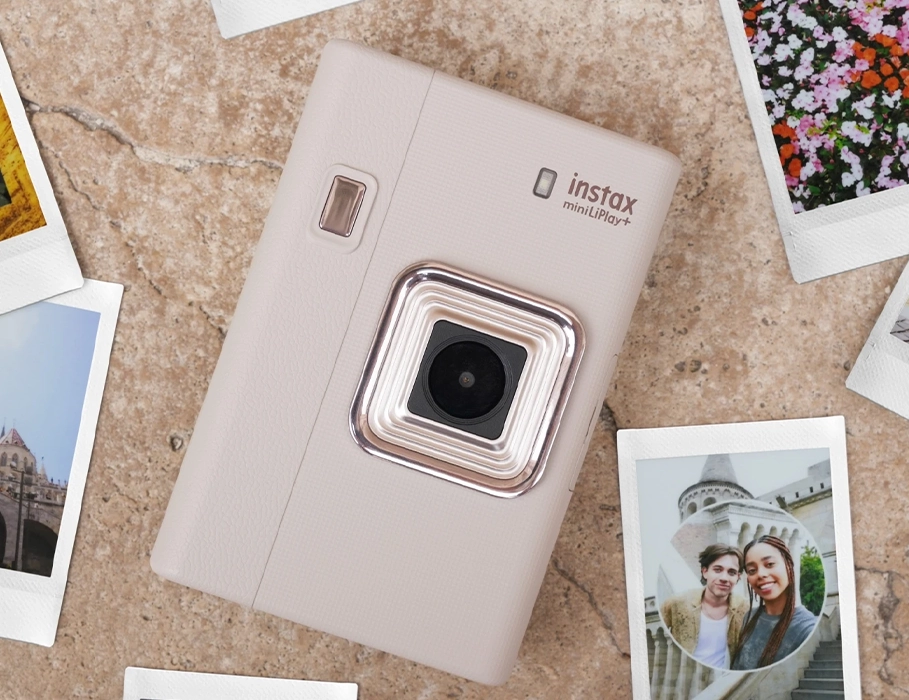 instax mini LiPlay+ на столе вместе с напечатанными фотографиями