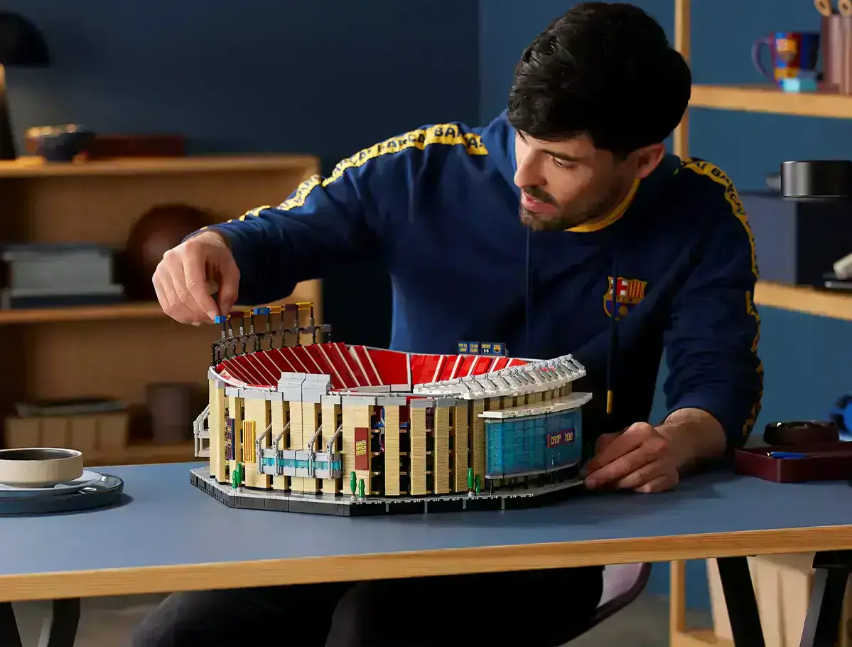 чоловік складає конструктор lego Стадіон Камп Ноу ФК Барселона