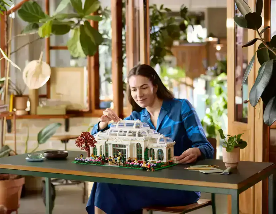 Фасад LEGO Ботанічного саду з мініфігурками відвідувачів та квітучими півоніями на подвір’ї