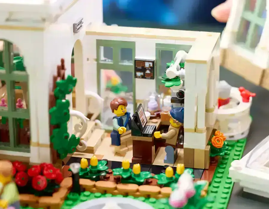 Сцена з LEGO набору: садівник LEGO доглядає за рослинами біля сухого саду