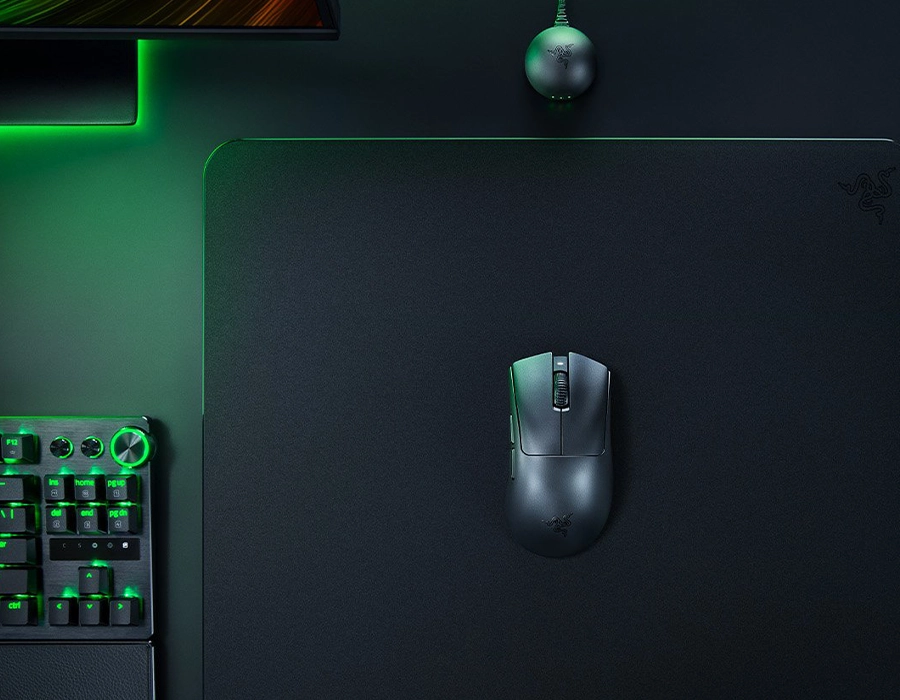 Razer DeathAdder V4 Pro на коврике рядом с клавиатурой