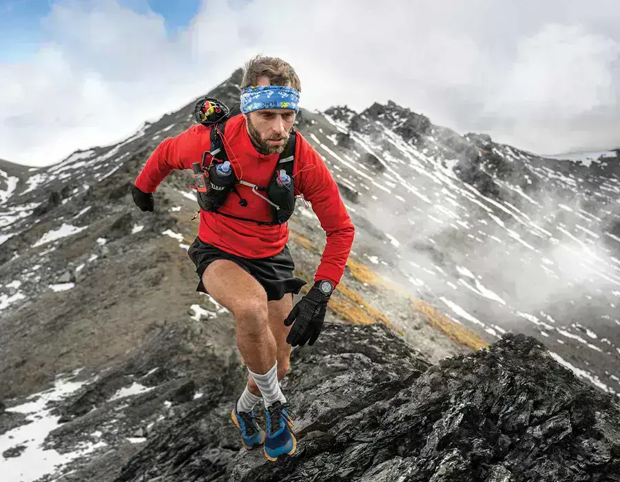 чоловік біжить по горі з годинником garmin enduro