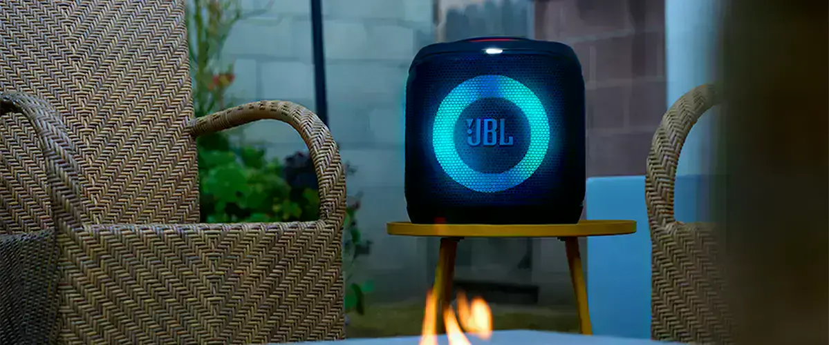 Портативная колонка JBL PartyBox Encore Essential 2 на столе в интерьере