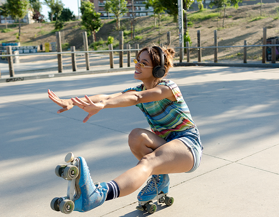 Наушники JBL Tune 530BT крупным планом на девушке, во время занятий