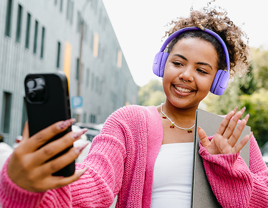 Наушники JBL Tune 530BT вместе со смартфоном, девушка общается по видеосвязи