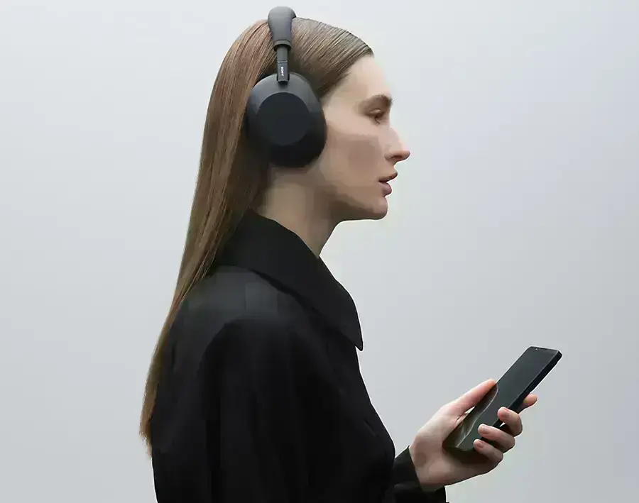 Жінка у навушниках Sony WH-1000XM6 під час дзвінка в шумному середовищі